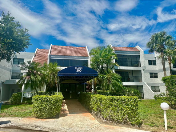 Front view of a multi-story building with a red-tiled roof and balconies.
