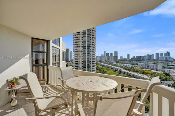 Balcony view from a high-rise building overlooking the cityscape with multiple tall buildings.