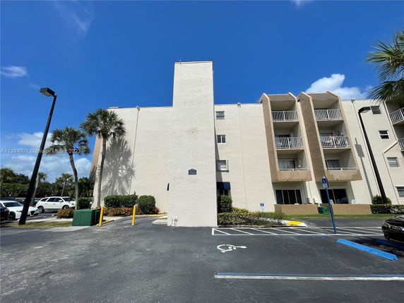 Front view of a multi-story apartment building with balconies.