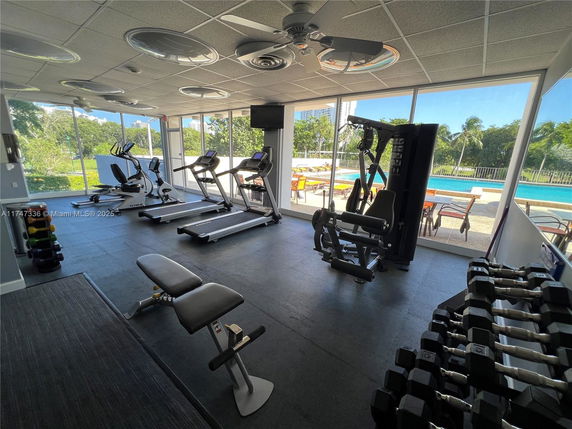 Indoor gym area with exercise equipment and large windows.