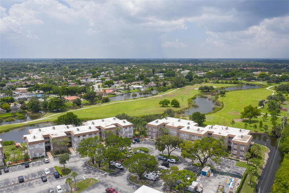 Wide-angle view of apartment complexes with surrounding green spaces and water bodies.