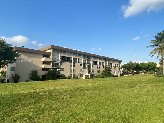 Front view of a multi-story apartment building with balconies.