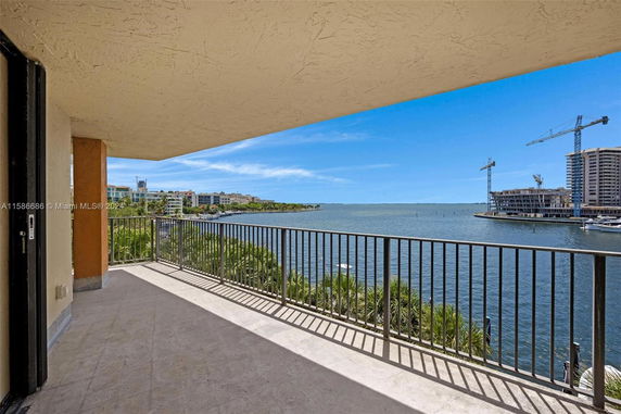 Balcony view overlooking water and nearby buildings under construction.