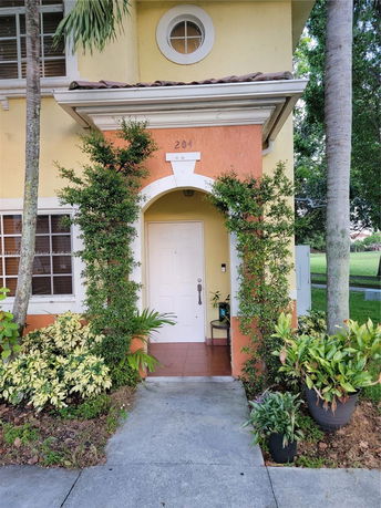Front view of a two-story house with decorative plants around the entrance.