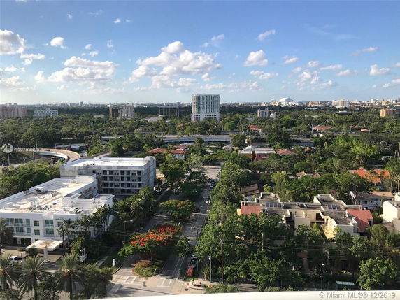 Wide-angle view of a cityscape with buildings and greenery.