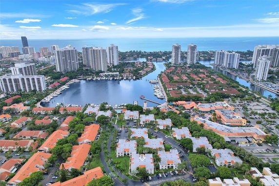 Panoramic view of a coastal city with high-rise buildings and a marina.
