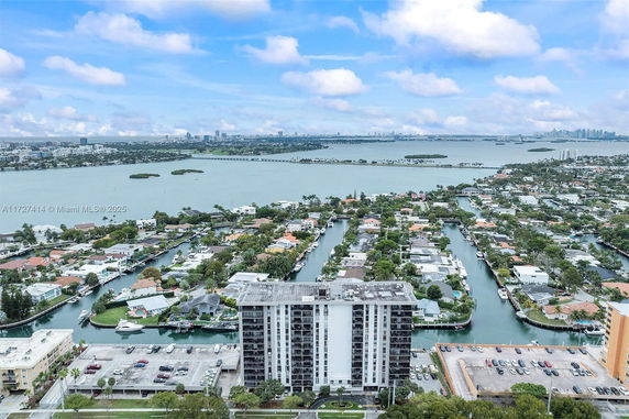 Aerial view of a waterfront residential area with a high-rise building and surrounding waterways.