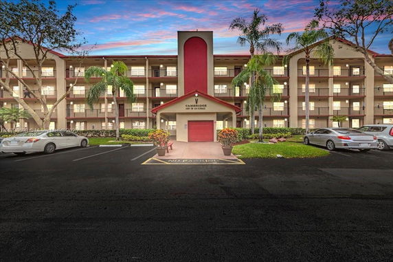 Front view of a multi-story residential building with parking area.