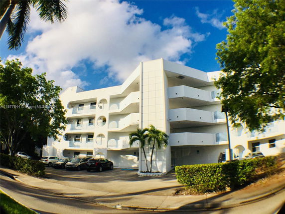 Front view of a multi-story apartment building with balconies.