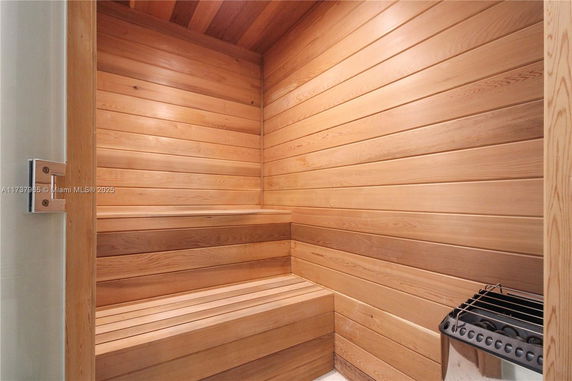Interior view of a wooden sauna room with benches and a heater.