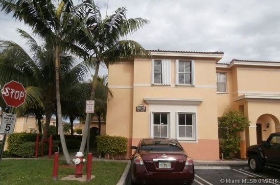 Front view of a two-story residential building with parking area.