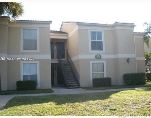 Front view of a two-story apartment building with an external staircase.
