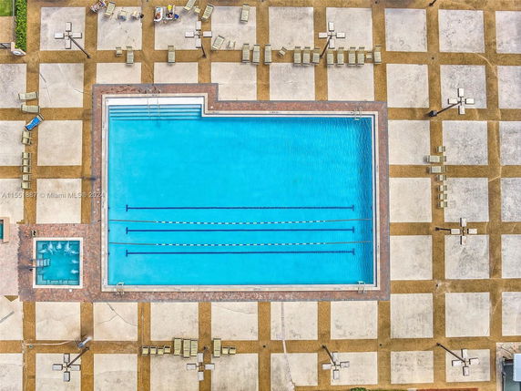 Aerial view of a swimming pool with surrounding lounge chairs and patio design.