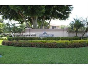 Entrance of a residential community with landscaping and a sign.