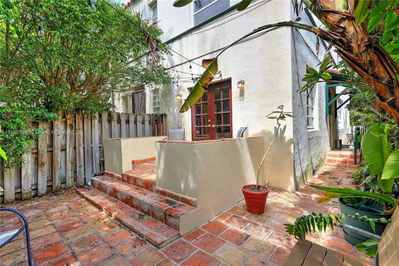 Elevated area of a house with terracotta tiles and a wooden fence.