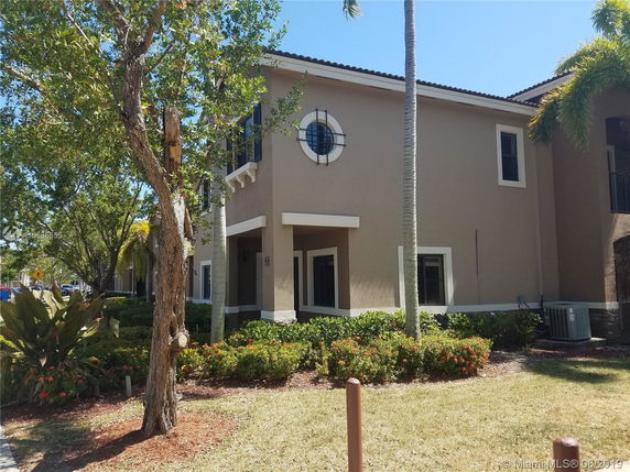 Front view of a two-story house with circular window and landscaping