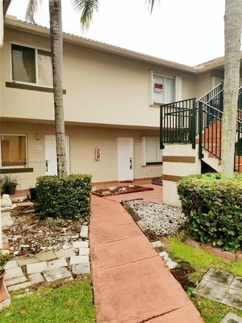 Front view of a two-story residential building with external staircase.