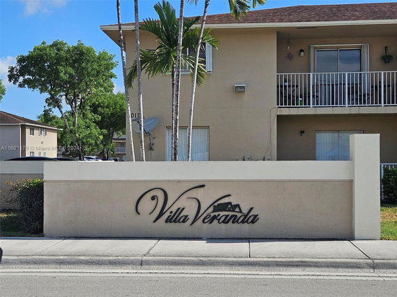 Front view of an apartment building with a balcony and sign reading 'Villa Veranda'.
