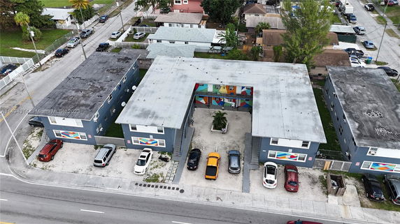 Aerial view of several buildings with a central courtyard and parking spaces.