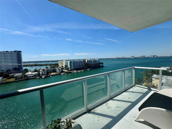 Balcony view showing waterfront skyline and buildings.