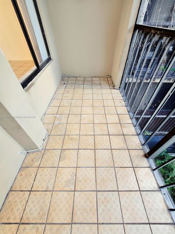 Small tiled balcony view with metal railing.