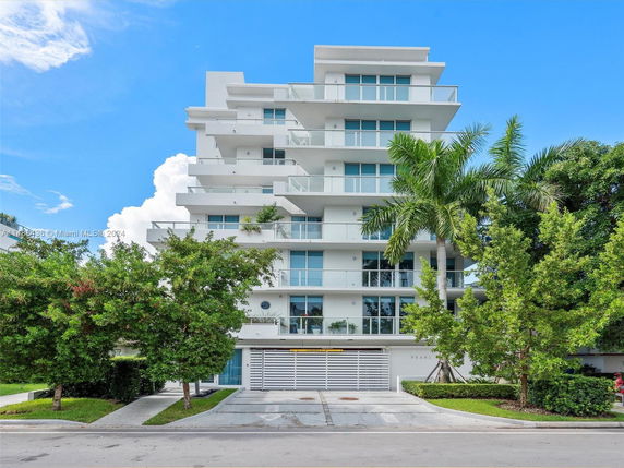 Front view of a multi-story modern residential building with balconies.