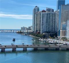 View of waterfront high-rise buildings and a bridge over a body of water.