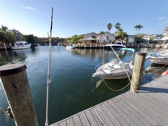 View of a waterfront area with boats docked along a wooden pier.