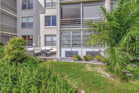 Front view of a multi-story building with a patio and outdoor seating area.