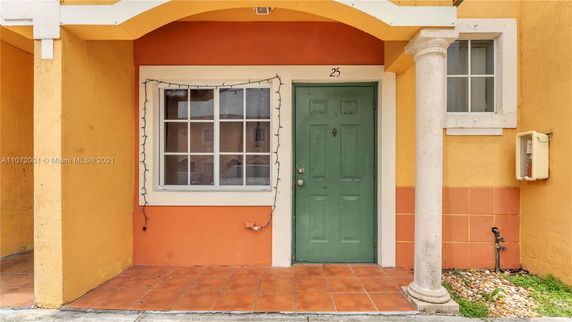 Front view of a house with a green door and orange facade.