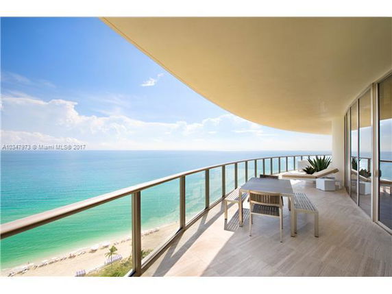 Wide-angle view from a balcony overlooking a beach and ocean.