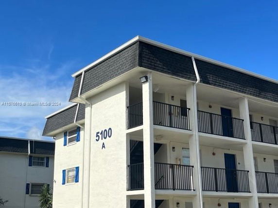 Front view of a three-story apartment building with balconies and numbered address 5100 A.