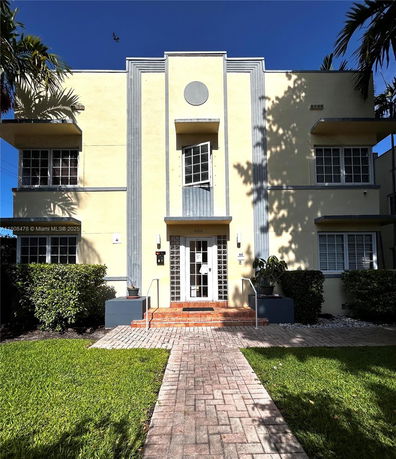 Front view of a two-story building with a central entrance and symmetrical windows.