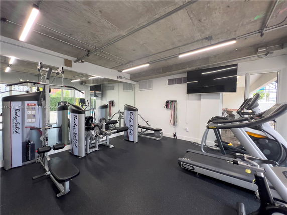 Indoor gym area with exercise equipment including treadmills and weight machines.
