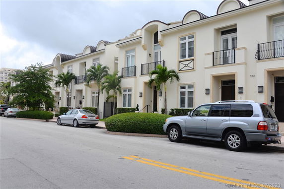 Front view of a row of two-story townhouses with balconies and well-maintained landscaping.