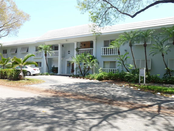 Front view of a two-story building with white columns and balconies.