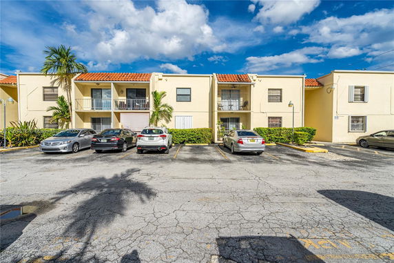 Front view of a residential building with parking area.