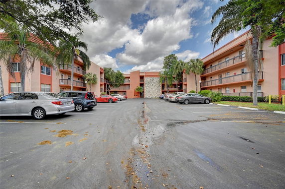 Parking area in front of a multi-story residential building.