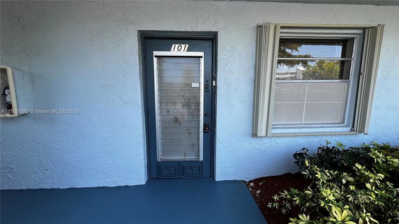 Front view of a building with a door and window.