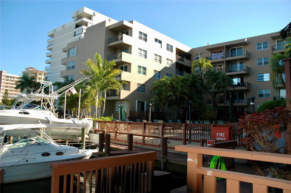 Front view of a multi-story building with balconies near a waterfront
