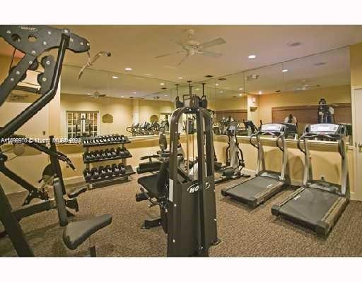 Indoor gym with exercise equipment including treadmills and weights.