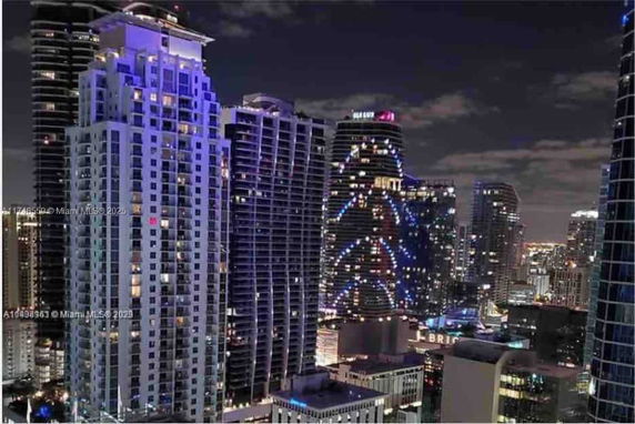 Nighttime view of city skyscrapers with illuminated high-rise buildings.