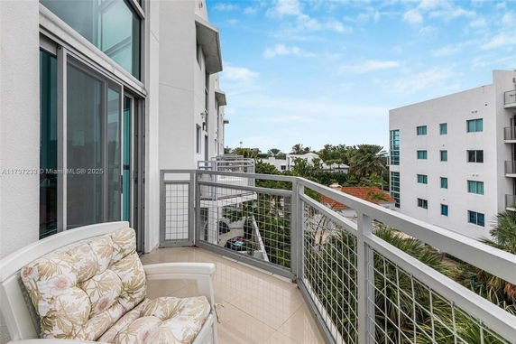 View from a balcony showing surrounding modern buildings and greenery.
