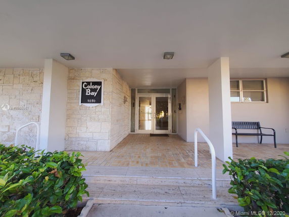 Front view of a building entrance with a sign reading 'Colony Bay 9250'.