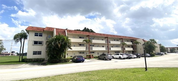 Front view of a three-story apartment building with balconies.