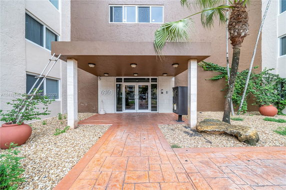 Front view of a multi-story building entrance with a covered walkway.
