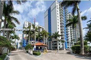 Front view of a modern multi-story residential building with palm trees.