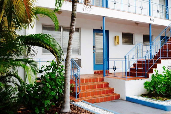 Front view of a multi-story building with blue railings and stairs.
