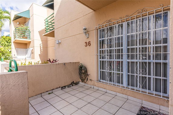 Front view of a residential building with a balcony and decorative window grills.