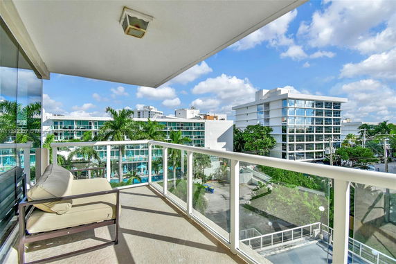 View from a balcony showing multiple modern apartment buildings and clear blue sky.